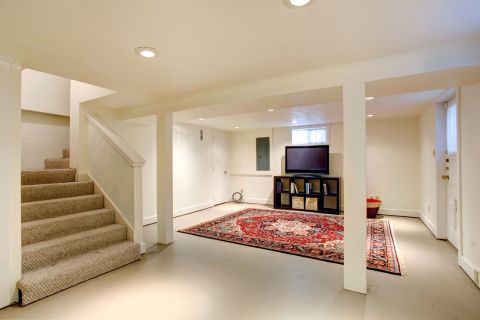 Technician performing basement flood cleanup services in NYC using HEPA equipment and eco-safe products