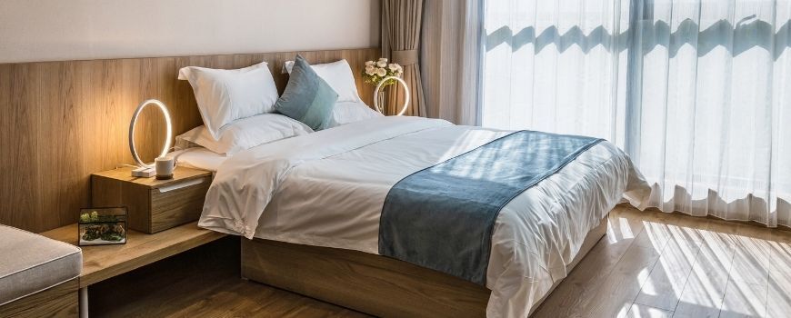 Neat and organized bedroom with natural light, showcasing results of a move in cleaning checklist.