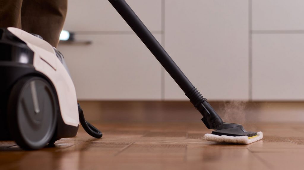 HEPA vacuum cleaning construction dust from hardwood floors during post-renovation cleaning in a remodeled home.