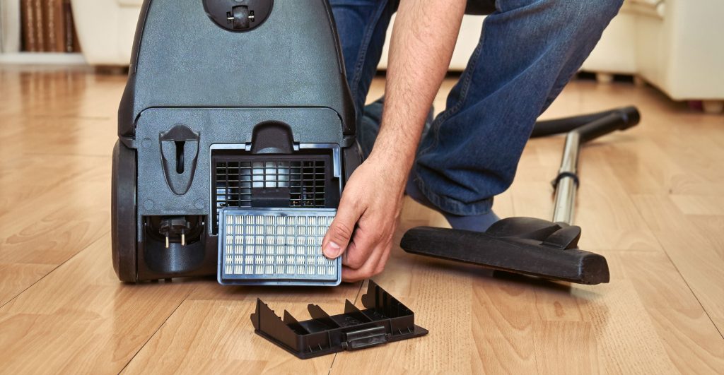 HEPA vacuum filter replacement during construction dust cleanup after home renovation and remodeling work.