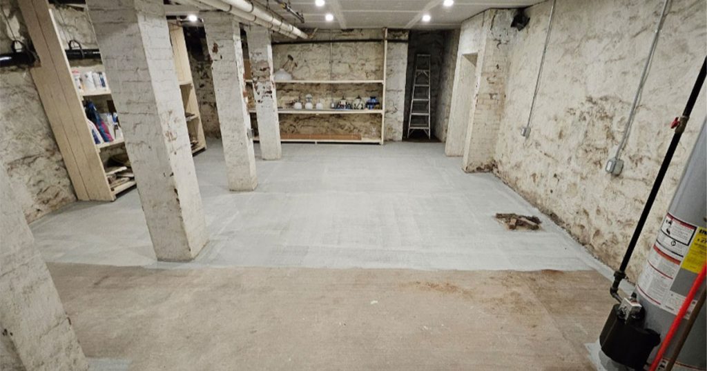 Concrete basement floor coating installation after deep basement cleaning and surface preparation