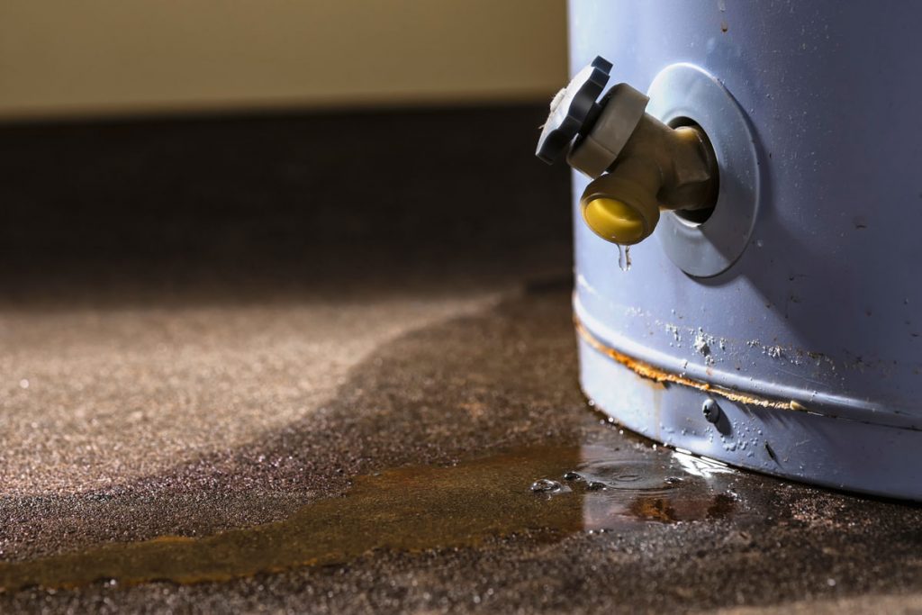 Leaking water heater causing water damage on a basement floor, a common source of basement flooding and emergency basement flood cleanup needs