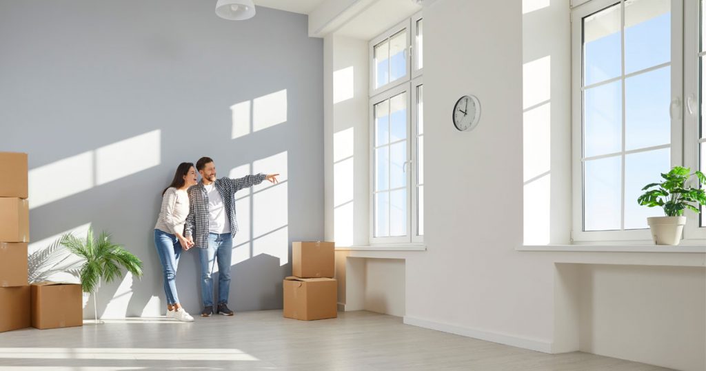 Couple standing in a clean, empty home after move-in cleaning before unpacking boxes