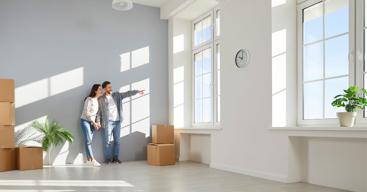 Couple standing in a clean, empty home after move-in cleaning before unpacking boxes