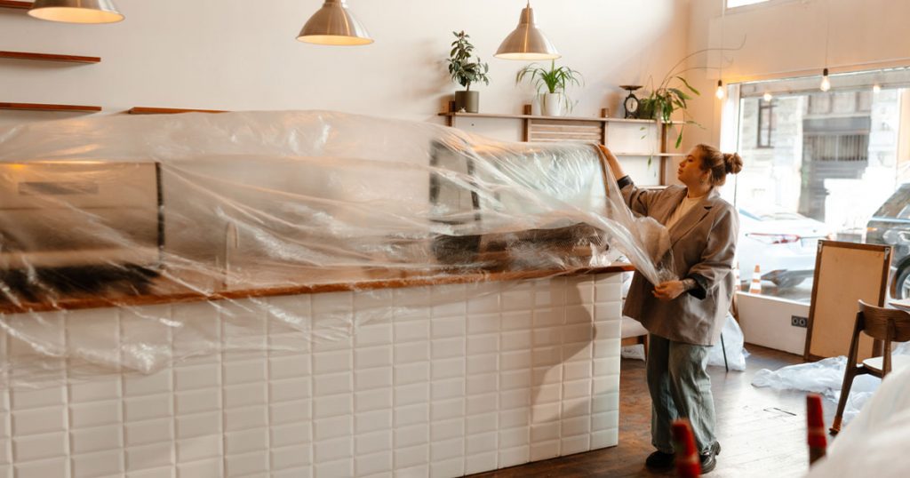 Plastic containment protecting furniture during a renovation before HEPA air scrubbing and post-construction cleaning.
